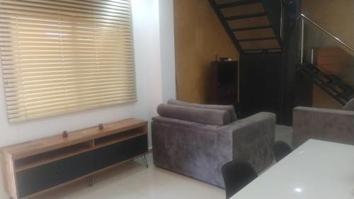 a living room with a couch and a chair at Zen Garden Experience - Inn & Bistrô in Foz do Iguaçu