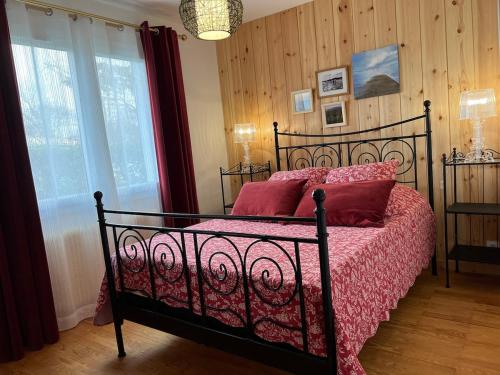 - une chambre avec un lit noir et des oreillers rouges dans l'établissement ARES - Maison le Paradis, à Arès