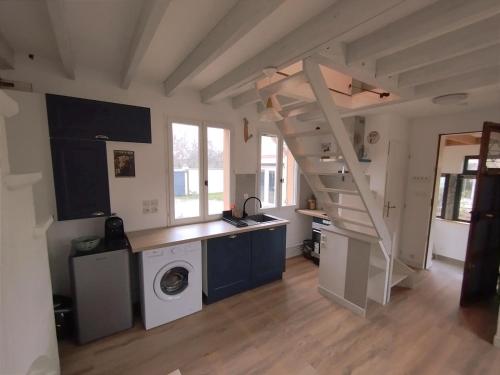 un salon avec un escalier et un lave-linge dans l'établissement Maisonette au calme, à Saint-Pierre-du-Perray