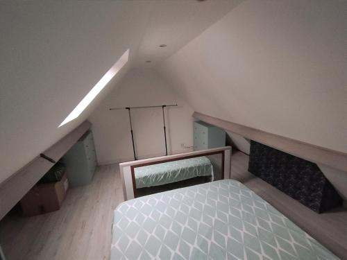 - une chambre mansardée avec un lit dans l'établissement Maisonette au calme, à Saint-Pierre-du-Perray