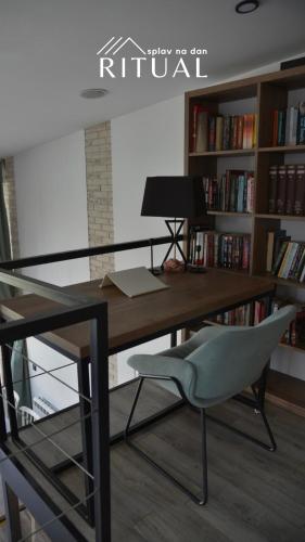 an office with a desk and a chair and bookshelves at Ritual splav in Belgrade