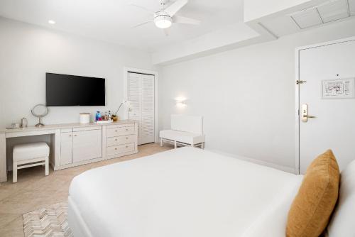 a white bedroom with a bed and a tv at Cardozo Hotel in Miami Beach