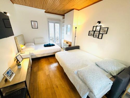 Zimmer mit 2 Betten und einem Tisch mit einem Schreibtisch in der Unterkunft Appartement porte de Saint Ouen in Paris