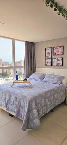 a large bed in a bedroom with a large window at Flat Hera 901 - Wi-fi, Vista mar a 300m da praia in Cabedelo