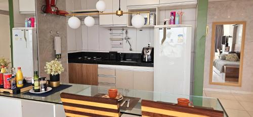 a kitchen with a glass table and a refrigerator at Flat Hera 901 - Wi-fi, Vista mar a 300m da praia in Cabedelo