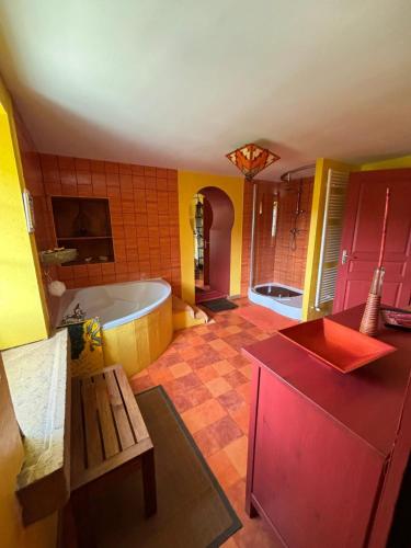 une grande salle de bain avec une baignoire et un lavabo dans l'établissement Appartement spacieux à Chenevrey-et-Morogne 160 m² avec terrasse, à Chenevrey-et-Morogne