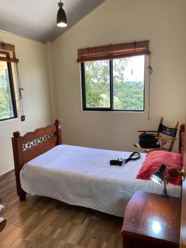 a bedroom with a bed and a table and a window at Campo y Descanso 15 min Ciudad in Popayan