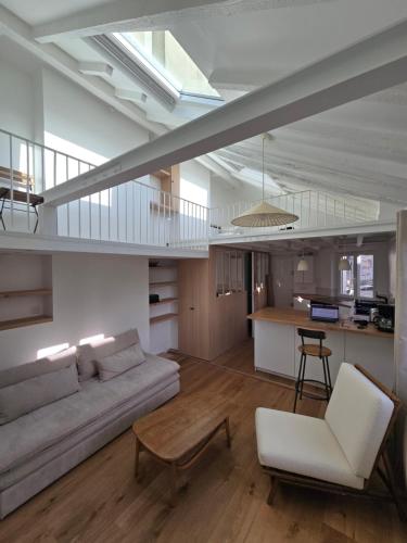 un salon avec un canapé et une table dans l'établissement Studio duplex plein sud refait à neuf - paris 2ème - vue exceptionnelle toits, à Paris