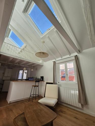 un salon avec une table et une fenêtre dans l'établissement Studio duplex plein sud refait à neuf - paris 2ème - vue exceptionnelle toits, à Paris