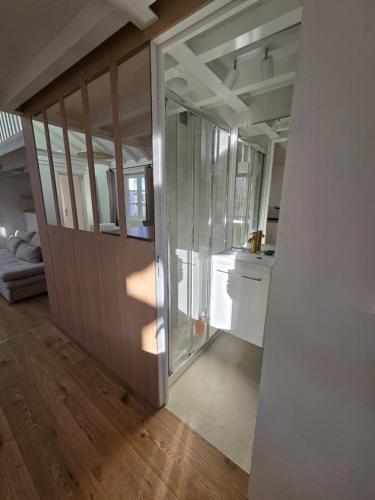 une chambre avec une porte coulissante en verre dans une cuisine dans l'établissement Studio duplex plein sud refait à neuf - paris 2ème - vue exceptionnelle toits, à Paris