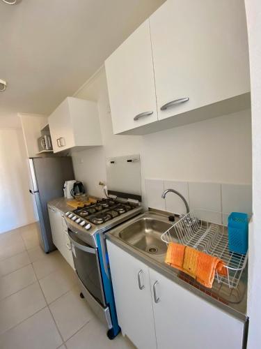 a kitchen with a sink and a stove at Departamentos Caldera Suites in Caldera
