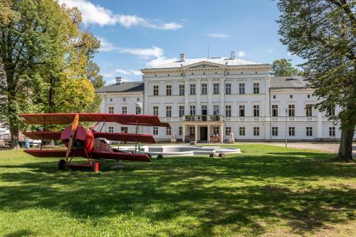 un aereo rosso parcheggiato di fronte a un grande edificio di Apartament Silver - Głuszyca - Góry Sowie a Głuszyca