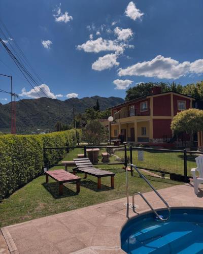 - une piscine avec une table de pique-nique et un banc à côté d'un bâtiment dans l'établissement Complejo Los Paraisos - Pileta Climatizada, à Potrero de los Funes