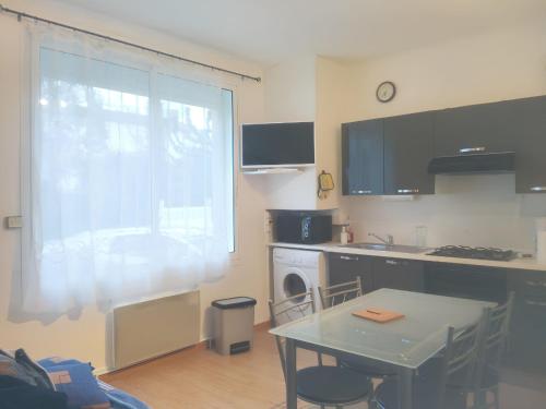 une petite cuisine avec une table et une fenêtre dans l'établissement Appartement agréable à Jonzac de 35 m² avec parking privé, à Jonzac