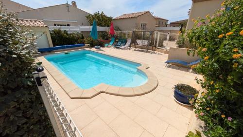 une piscine dans une cour avec un patio dans l'établissement La Villa de la Mer pour 10, à Gruissan