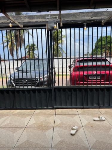 a door with a red suitcase and a car behind it at Salinas Dei Fiori in Salinópolis