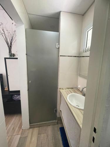 a bathroom with a sink and a door at Ezeiza 3 departamento privado a 15 minutos del aeropuerto hasta 7 personas OPCIONAL TRANFER DESDE Y HACIA EL AEROPUERTO DE EZEIZA LAS 24 HORAS pet friendly conexion con Aeroparque in Ezeiza