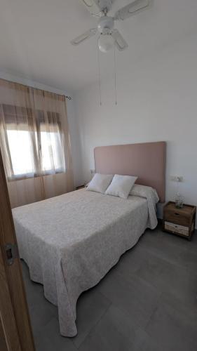 a bedroom with a bed and a ceiling fan at APARTAMENTOS LA PALMERA in Fernán Pérez