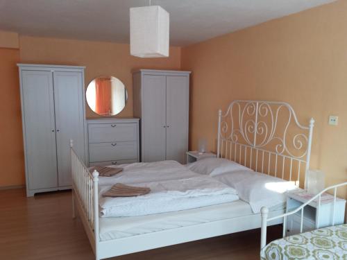 a bedroom with a white bed and a mirror at Apartmány Korenko in Štrba