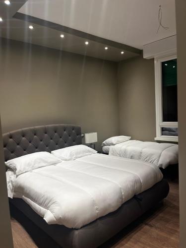 a bedroom with three beds with white sheets at Stazione Tiburtina Roma in Rome
