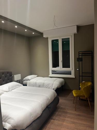 a room with three beds and a chair and a window at Stazione Tiburtina Roma in Rome