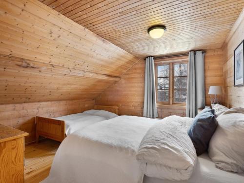 two beds in a room with a wooden ceiling at Sirdal Fjellhytte - Holiday home at Sinnes in Haugen