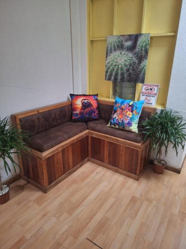 a couch sitting in a room with two pillows at Hotel Cortez Azul in Alajuela City