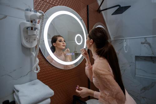 a woman brushing her teeth in front of a mirror at JEZERSKA RESIDENCE Palić in Palić