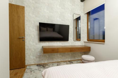 a bedroom with a flat screen tv on the wall at JEZERSKA RESIDENCE Palić in Palić