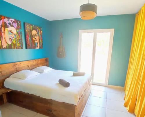 une chambre avec un lit aux murs bleus et une fenêtre dans l'établissement Villa piscine. Plage à 20 min lac à 5min, à Roquebrune-sur Argens