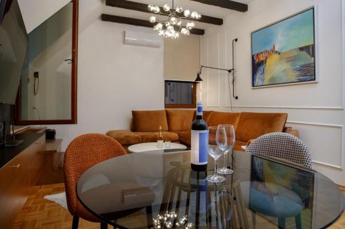 a living room with a glass table with a bottle of wine at JEZERSKA RESIDENCE Palić in Palić