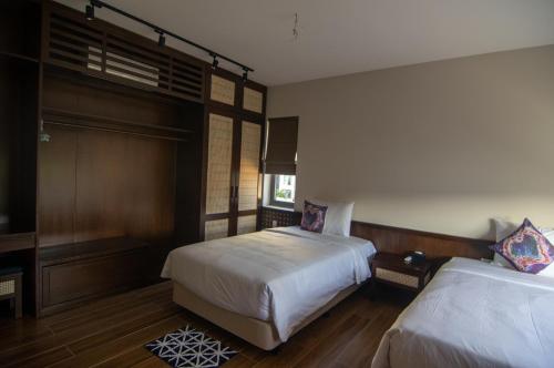 a bedroom with two beds and a window at Sealight Villa and House Phu Quoc in Phu Quoc