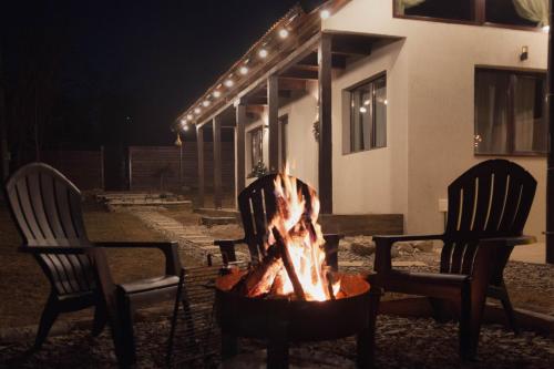 two chairs and a fire pit in front of a house at TheAttic in Corbeni