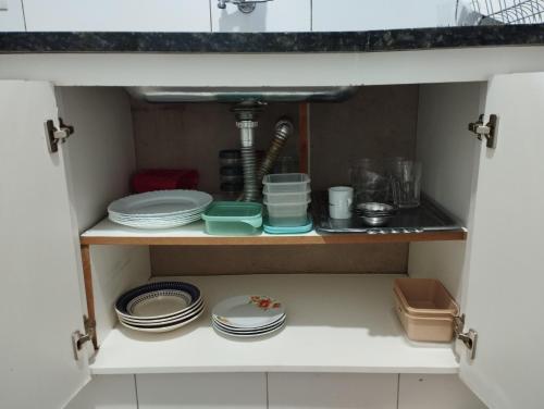 a cupboard with plates and dishes in a kitchen at Casa Presidente Venceslau in Presidente Venceslau