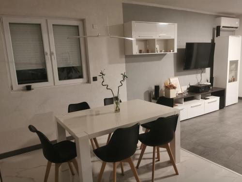 a dining room with a white table and chairs at Vila V & S in Star Dojran