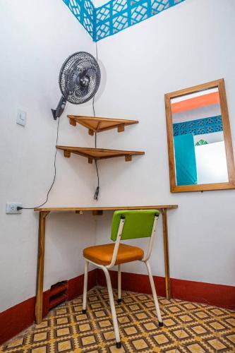 a desk with a green chair and a fan at Hotel Kasa Dokari in Honda