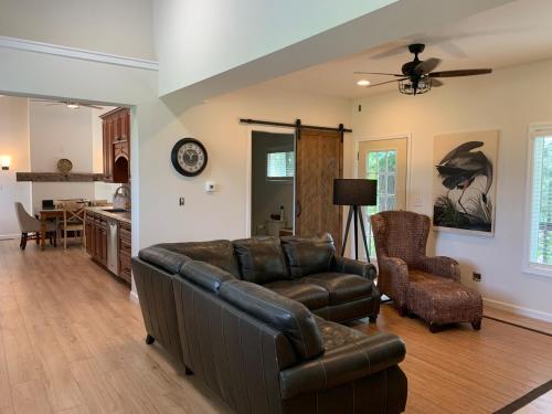 a living room with a leather couch and a chair at Lazy Lake Life Awaits! in Monticello