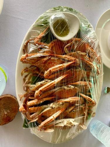 a plate of shrimp with a bowl of dipping sauce at PhaluayCamping in Koh Phaluai