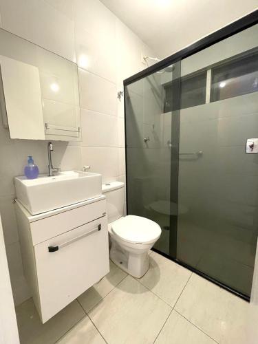 a bathroom with a toilet and a sink and a shower at Apart com garagem em cond próx à Orla in Petrolina