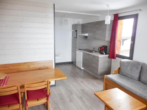 un salon avec une table et un canapé dans l'établissement Appartement charmant à La Plagne-Tarentaise avec balcon & vue, à La Plagne Tarentaise
