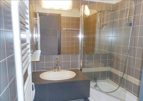 une salle de bain avec un lavabo et une douche dans l'établissement Appartement charmant à La Plagne-Tarentaise avec balcon & vue, à La Plagne Tarentaise