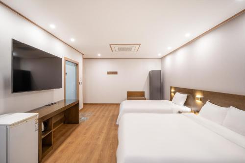 a hotel room with two beds and a flat screen tv at The 7 Business Hotel in Gumi