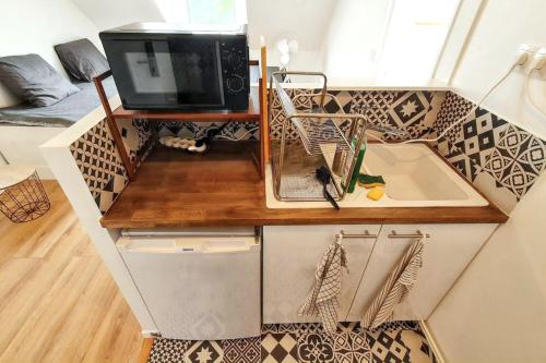 a small kitchen with a sink and a tv on a counter at Charmant appartement à Magny-le-Hongre, 35 m², au calme in Magny-le-Hongre