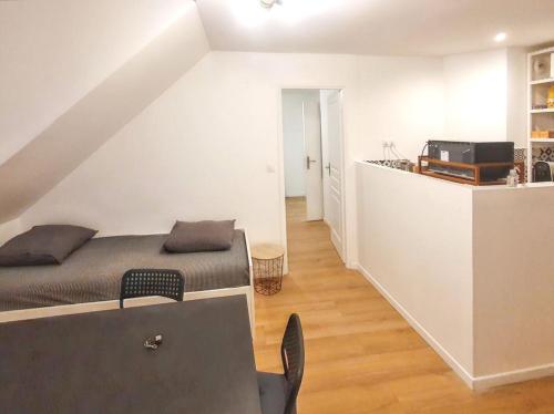 un salon avec un lit et une cuisine dans l'établissement Charmant appartement à Magny-le-Hongre, 35 m², au calme, à Magny-le-Hongre
