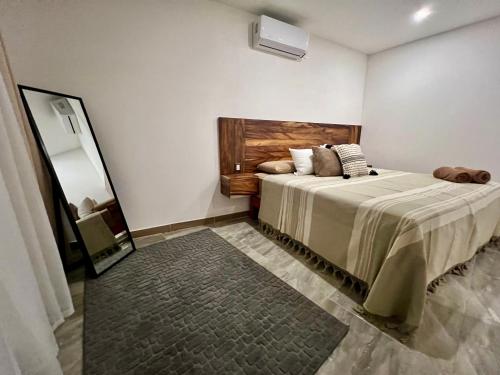 una camera da letto con un letto grande e uno specchio di Huitzilin Hostal a Brisas de Zicatela