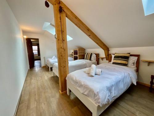 - 2 lits dans une chambre dotée de poutres en bois dans l'établissement Le Grand Loup, appartement neuf avec bain nordique, à Gerbépal