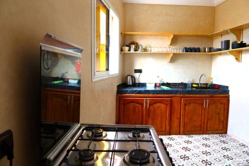 a kitchen with a stove and a counter top at Little Beach House Sidi Kaouki in Sidi Kaouki