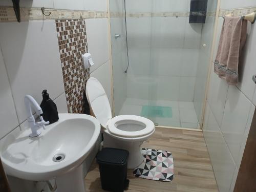 a bathroom with a toilet and a sink and a shower at Casa Premium in Blumenau