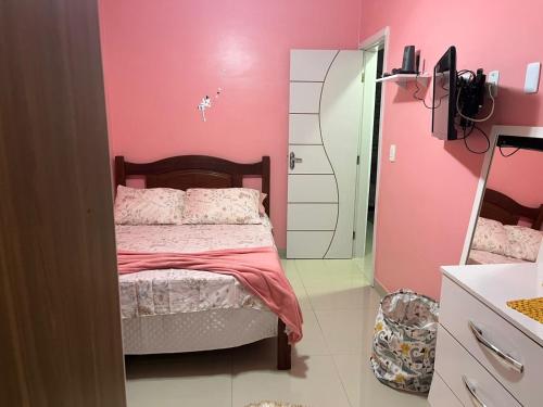 a pink bedroom with a bed and a mirror at Residence -10 minutos andando até o Estadio do Mangueirão in Belém