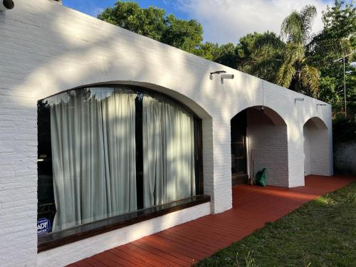 una casa in mattoni bianchi con una grande finestra di Cero estres a Punta del Este
